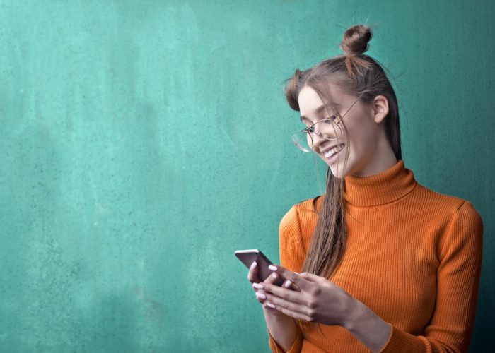 A girl holding smartphone to book home tutors