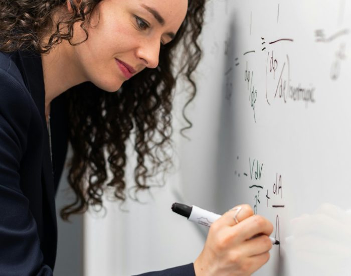 Woman Writing Formula on Whiteboard